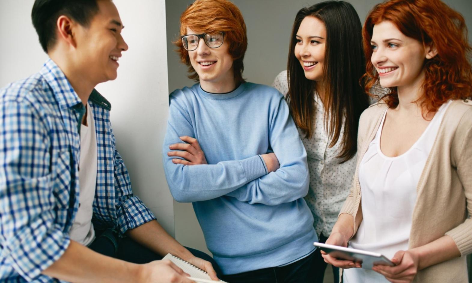 Aula moderna con estudiantes colaborando en proyectos fintech utilizando múltiples pantallas